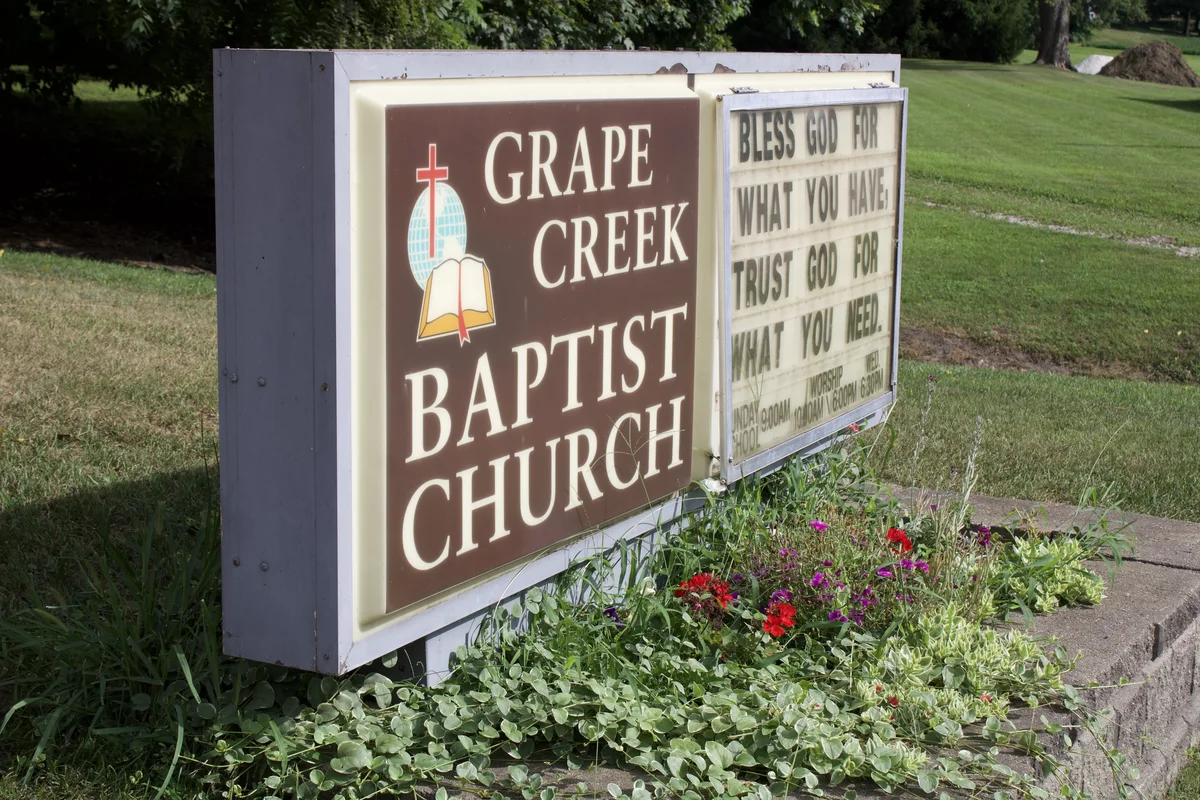 Grape Creek Baptist Church sign with flowers